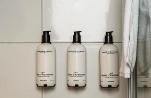 a group of four shampoo bottles on a shelf at Boutique Hotel Lumiere in Eindhoven +71 photos