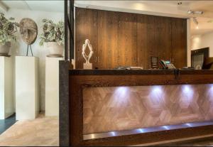 a lobby with a wooden wall and a desk at Boutique Hotel Lumiere in Eindhoven