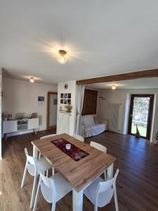 a living room with a wooden table and white chairs at Casa Jedi in Santa Maria Maggiore