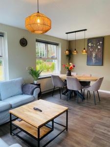 a living room with a couch and a table at Morning Glory, Huisje Dahlia in Beekbergen