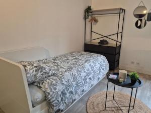 a small bedroom with a bed and a table at Studio - Le Cocon in Saint-Brieuc