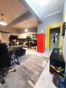 a living room with a red refrigerator and a dining room at jim villa family apartment with private yard andravida-kyllini in Andravída