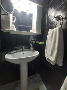 a bathroom with a white sink and a mirror at jim villa family apartment with private yard andravida-kyllini in Andravída