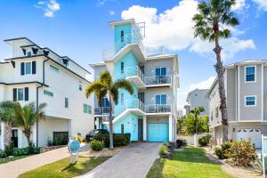 a large white building with blue doors and palm trees at A Somewhere is Here by Beachside Management in Siesta Key