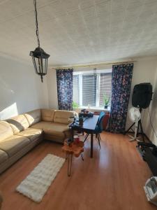 a living room with a couch and a table at Sunset Bird Watcher Apartament in Visaginas