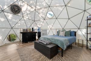 a bedroom with a bed in a glass walled room at Campfire Hollow in Eagle Rock
