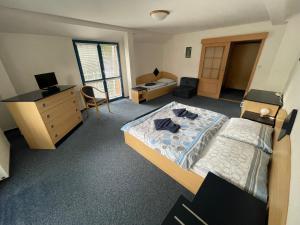 a bedroom with two beds and a dresser and a desk at U Konupy in Ober Lindewiese