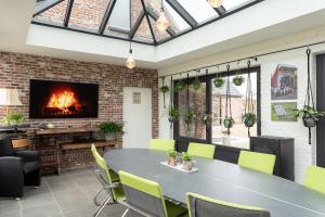 a conservatory with a table and chairs and a fireplace at Vakantiehoeve Breathe Nature in Lochristi
