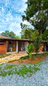 a small house with a porch and a tree at POUSADA PARLATORIUM in Tiradentes