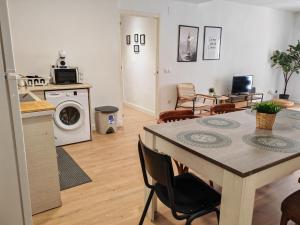 a kitchen and living room with a table and a washing machine at Boutique 2 apartamento Ave centro Lleida in Lleida