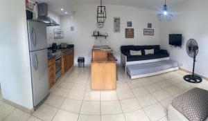 a kitchen with a refrigerator and a living room with a couch at Alojamiento en el centro de Salta - Casaguemessalta in Salta