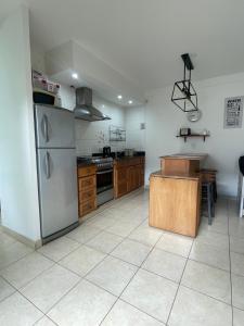 a large kitchen with stainless steel appliances and wooden cabinets at Alojamiento en el centro de Salta - Casaguemessalta in Salta +31 photos