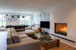 a living room with a couch and a fireplace at Vakantiehoeve Breathe Nature in Lochristi