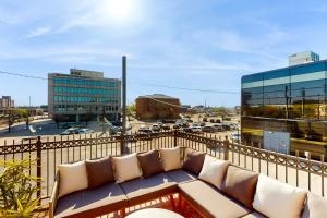 a couch sitting on a balcony with a view of a city at 'Downtown Delight' w/ Patio! 1 Mi to Ball State in Muncie