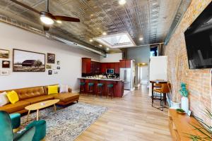 a living room with a couch and a kitchen at 'Downtown Delight' w/ Patio! 1 Mi to Ball State in Muncie