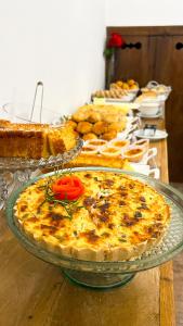 a table topped with a pizza and other pies at POUSADA PARLATORIUM in Tiradentes +76 photos