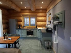 a kitchen with blue cabinets and a wooden wall at Ferienhaus Waldruhe in Hellenthal