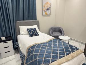a bedroom with a bed and a chair at Colour holiday Zayed in Sheikh Zayed