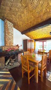 a dining room with a wooden table and a stone fireplace at POUSADA PARLATORIUM in Tiradentes