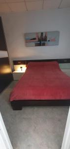 a bedroom with a red bed with a red blanket at Villa le Locle in Alicante