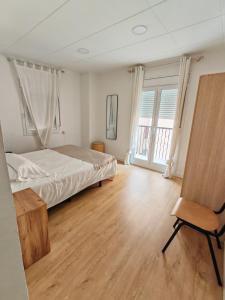 a bedroom with a bed and a chair in it at Boutique 2 apartamento Ave centro Lleida in Lleida