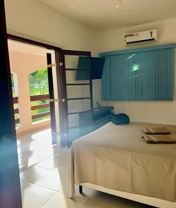 a bedroom with a bed and a sliding glass door at Refúgio na natureza com piscina e churrasqueira in Pedro de Toledo +37 photos