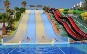 a water slide at a water park with three people on it at Piso en la Costa del Sol by BRISAMAR Holidays in Vélez-Málaga