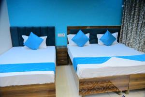 two beds in a room with blue walls at Vatika palace in Ayodhya