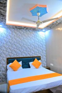 a bedroom with a bed with orange and blue pillows at Vatika palace in Ayodhya