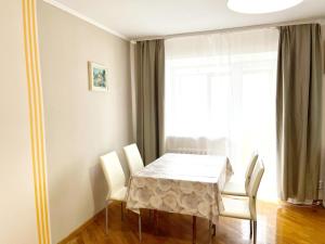 a dining room with a white table and chairs at Центр, 2х комнатная студио возле парка, WIFI in Vinnytsya
