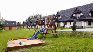 a playground in a yard in front of a house at Domki Pod Lasem Podhale in Zakopane