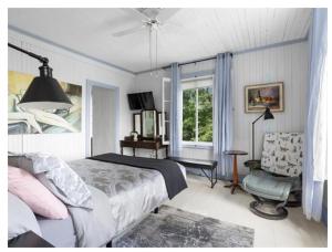 a bedroom with a bed and a chair and a window at La maison de l'île d'Orléans - B&B - déjeuner gastronomique in Saint-Jean