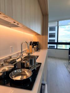 a kitchen with four pots and pans on a stove at District 225 in Miami
