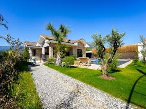 a house with a garden and a yard with trees at Citrus Stone House in Koycegiz