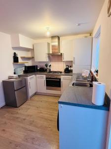 a kitchen with white cabinets and a counter top at Gloria's Getaway in Langport
