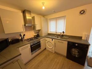 a kitchen with a washing machine and a sink at Gloria's Getaway in Langport +9 photos