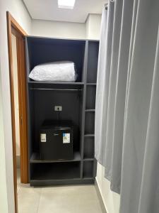 a room with a closet with a bed and a box at Dicopi Hotel in Maringá +18 photos
