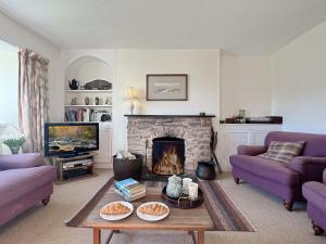 a living room with purple couches and a fireplace at Brightworthy Farm Withypool in Withypool
