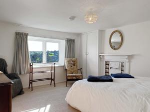 a bedroom with a bed and a chair and a window at Brightworthy Farm Withypool in Withypool
