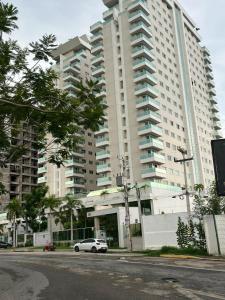 a white car parked in front of a large building at Seller Residence Centro in Sobral