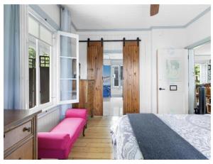a bedroom with a bed and a pink couch at La maison de l'île d'Orléans - B&B - déjeuner gastronomique in Saint-Jean +47 photos