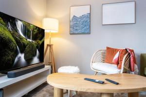 a living room with a tv and a coffee table at Coastal Wooden Apartment Rauma in Rauma