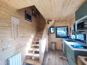 a wooden cabin with a staircase in a kitchen at chalet bohème au calme in Saint-Ambreuil