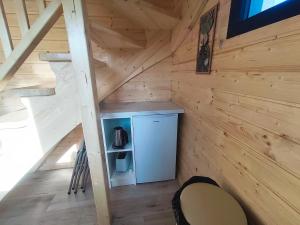 an attic room with a refrigerator in a wooden cabin at chalet bohème au calme in Saint-Ambreuil +6 photos