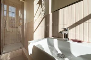 a white bathroom with a sink and a shower at Hotel Louvia in Menton +71 photos