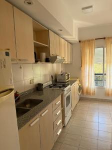 a kitchen with white cabinets and a stove top oven at Departamento Plumerillo in Santa Rosa