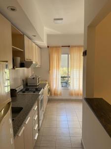 a kitchen with white appliances and a large window at Departamento Plumerillo in Santa Rosa