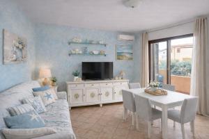 a living room with a couch and a table with a tv at Il Mirto apartment con piscina in Olbia