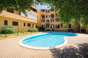 a swimming pool in front of a building at Il Mirto apartment con piscina in Olbia