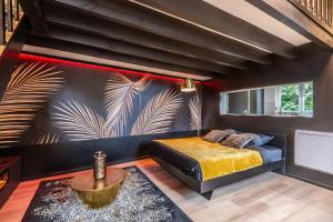 a bedroom with a bed and a wall with a mural at La Cachette - Suite romantique & balnéo privative in Hermeray